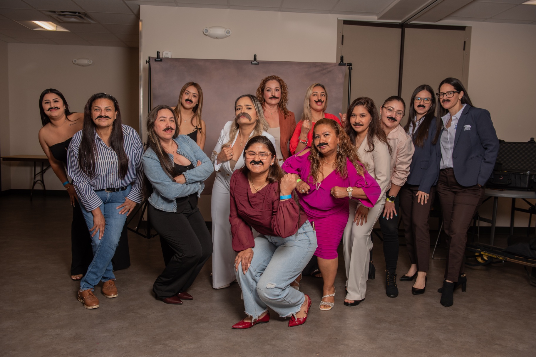 Mujeres del taller con bigotes simbolizando 'soltar el macho'